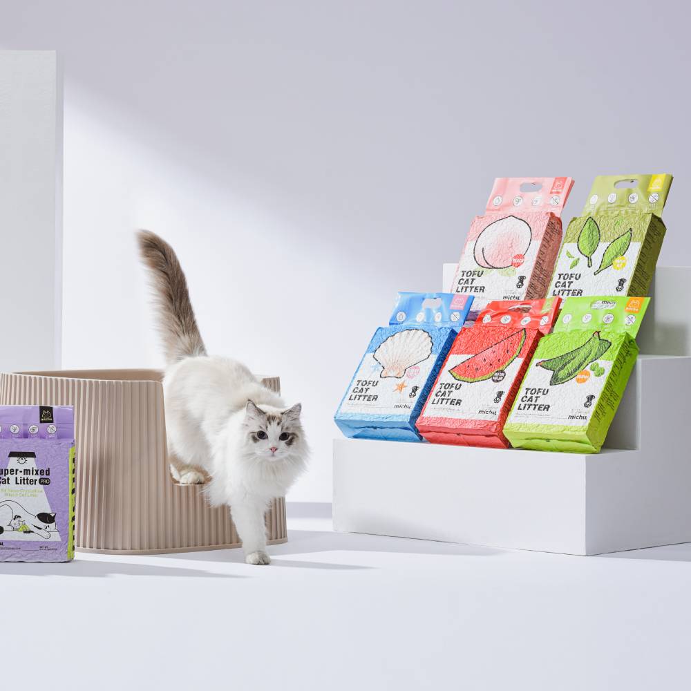 Cat sitting beside Michu tofu cat litter bags