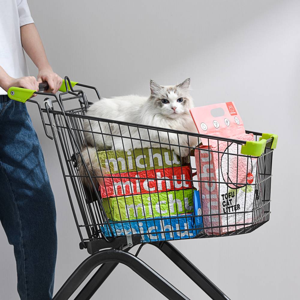 Cat sitting in shopping trolley with Michu tofu cat litter bags