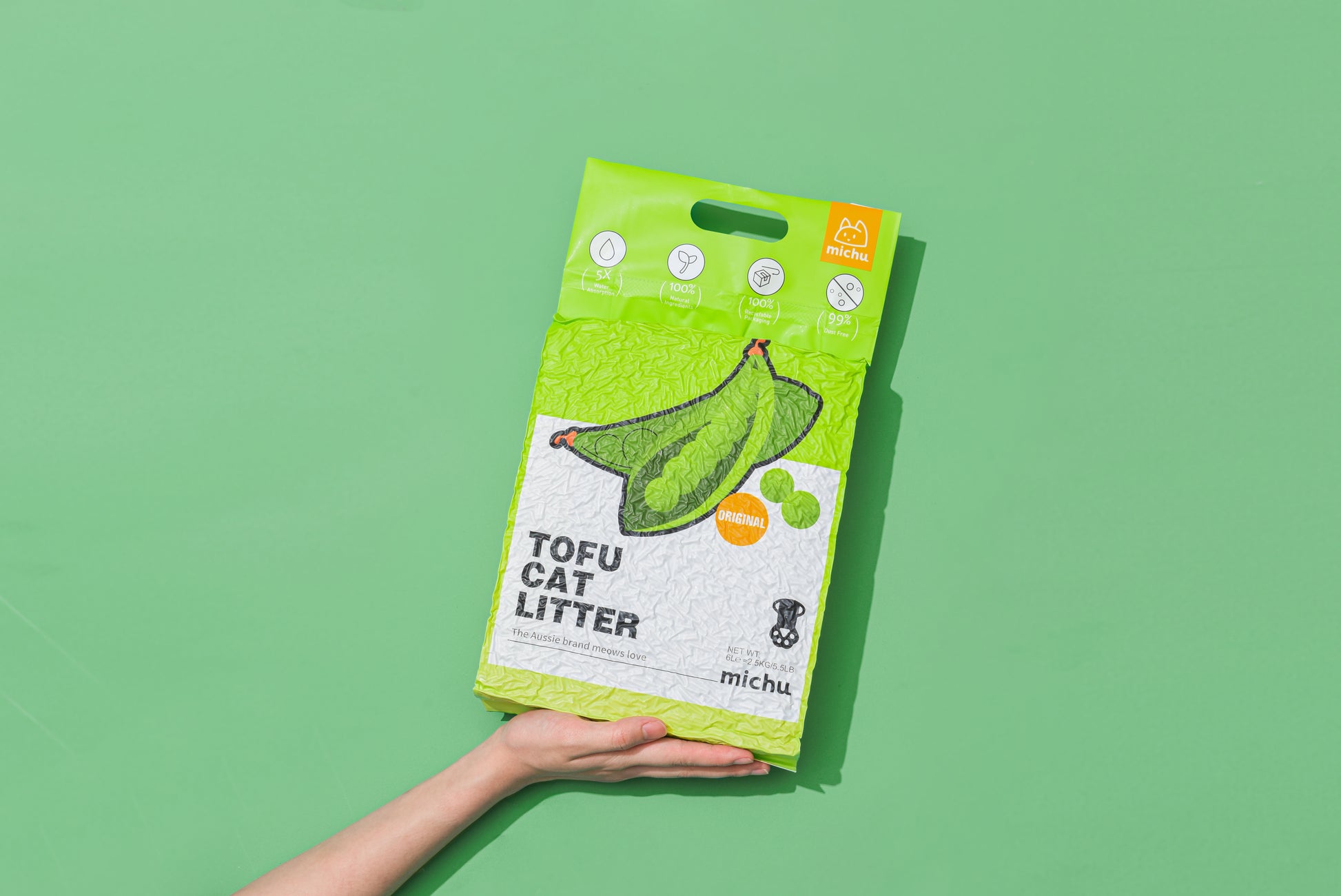 Hand holding Michu tofu cat litter original scent pack
